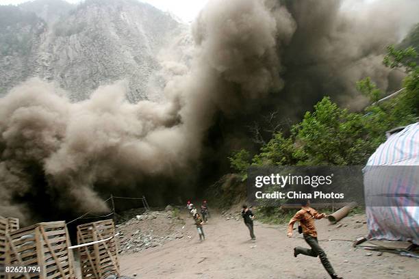 People run to escape from a landslide triggered by an aftershock on on May 17, 2008 in Lixian County of Wenchuan, Sichuan Province, China. A major...