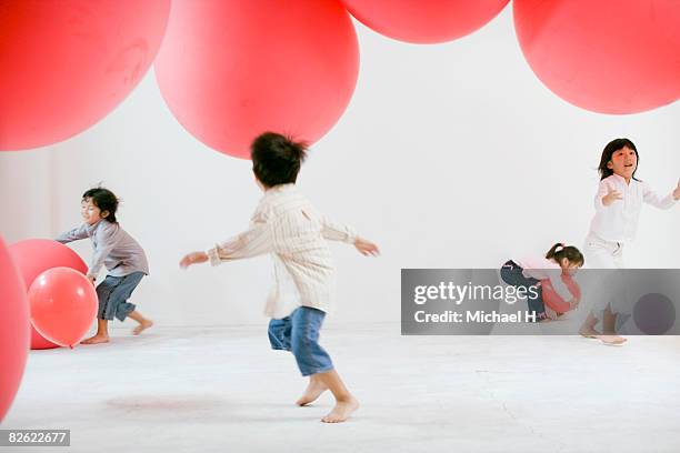 children playing with big red ballons  - gruppe h spiel stock-fotos und bilder