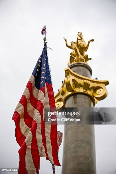 Golden statue of Saint George, the patron saint of Georgia, stands next to an American Flag in Republic Square during a peace rally on September 1,...