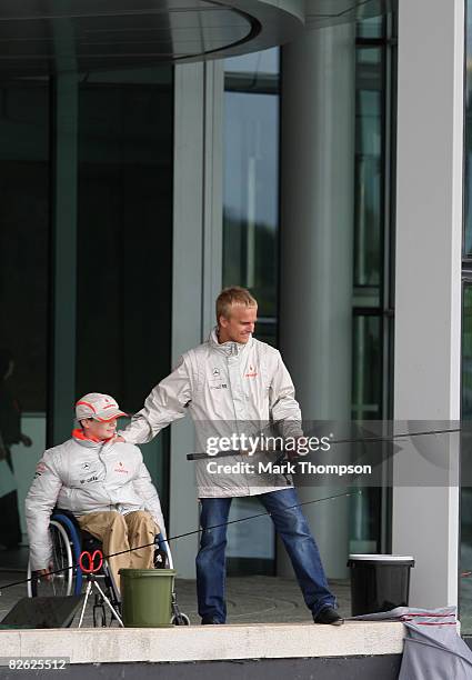 McLaren Formula 1 driver Heikki Kovalainen of Finland fishes with Liam Fairhurst, age 13, who has been fighting a battle with cancer for the past...