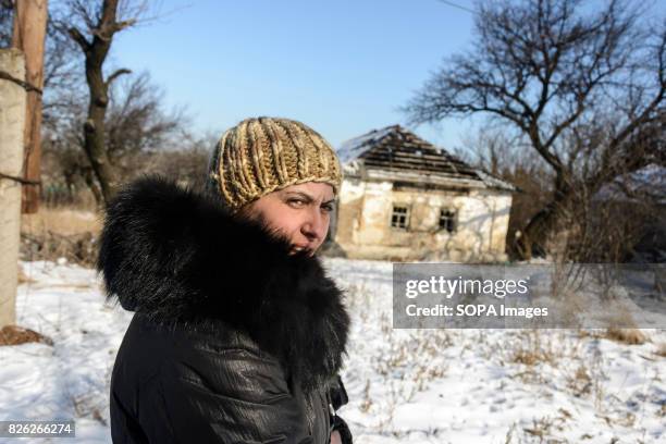 Oksana Sidorenko, who lives less than hundred meters from the front line, walks next to a destroyed building. Sporadic shelling and sniper fire...