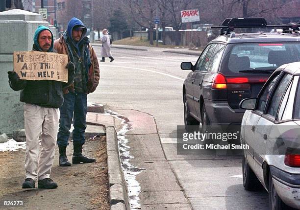 Rick Gomez and Kenny Langdon, both homeless, panhandle on a corner February 28, 2001 in downtown Denver, CO. The number of homeless people in the...