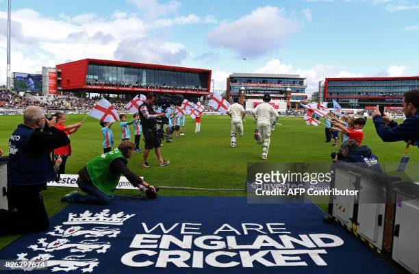 England's Keaton Jennings and England's Alastair Cook run onto the pitch on the first day of the fourth test at Old Trafford Cricket Ground in...