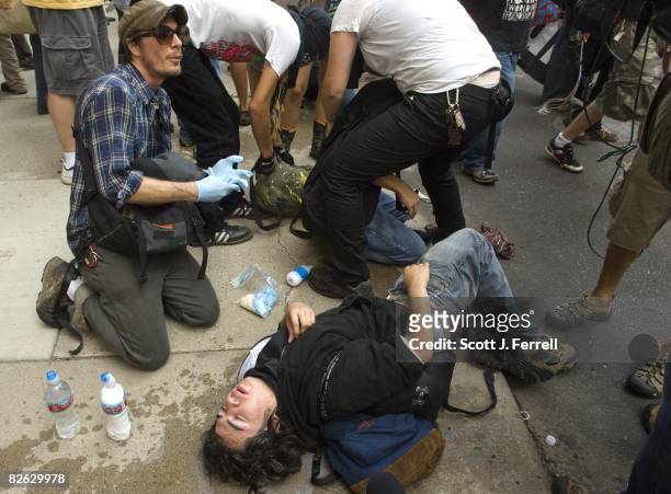 Anti-war protester is aided after he was sprayed with pepper spray by law enforcement after the protesters tried to diverge from the approved route...