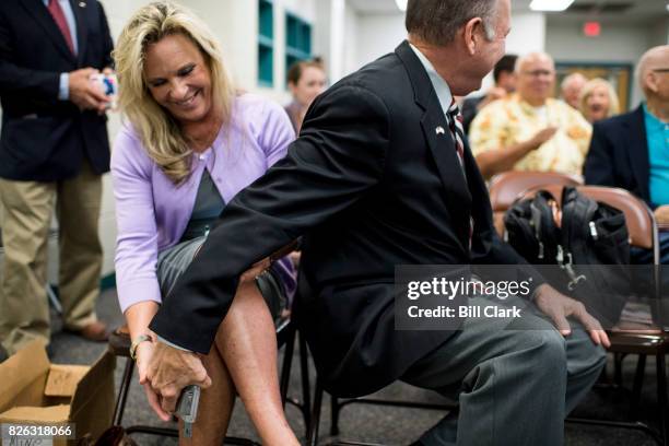 Candidate for U.S. Senate Roy Moore returns his wife's hand gun to her after displaying it as a way to show support for the 2nd amendment after...