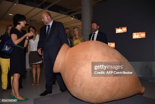 French Minister of Agriculture Stéphane Travert speaks with Georgia's Ambassador to France Sinadze Delaunay as they stand beside a terracotta wine...