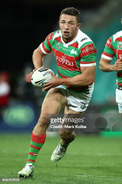 Sam Burgess of the Rabbitohs runs the ball during the round 22 NRL match between the St George Illawarra Dragons and the South Sydney Rabbitohs at...