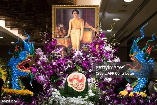 Painting depicting Thailand's Queen Sirikit adorns an elaborate fruit and vegetable decoration during a fruit and vegetable carving competition in...