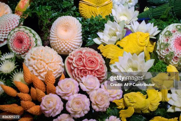 An elaborate display of carved fruits and vegetables is displayed during a fruit and vegetable carving competition in Bangkok on August 4, 2017. It...