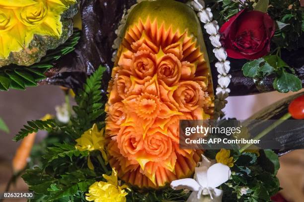 Carved papaya is displayed during a fruit and vegetable carving competition in Bangkok on August 4, 2017. It is a royal tradition that has proved...