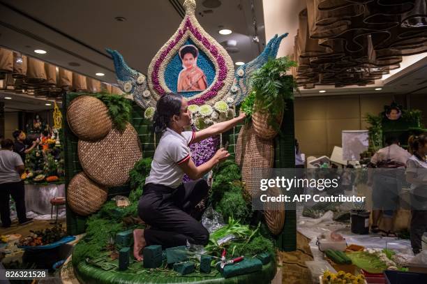 Thai woman puts together the background to a decoration that will include different vegetable and fruit decorations during a fruit and vegetable...