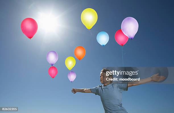 boy releasing balloons - releasing balloons stock pictures, royalty-free photos & images