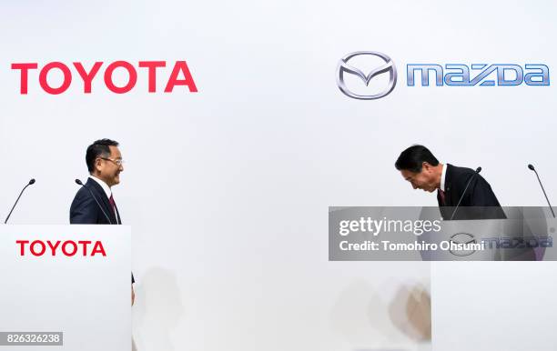 Toyota Motor Co. President Akio Toyoda, left, looks on as Mazda Motor Co. President and CEO Masamichi Kogai, right, bows at a joint press conference...