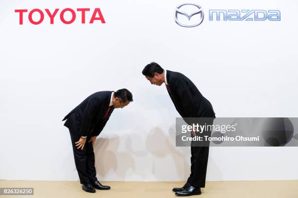 Toyota Motor Co. President Akio Toyoda, left, and Mazda Motor Co. President and CEO Masamichi Kogai, right, bow during a photo session at a joint...
