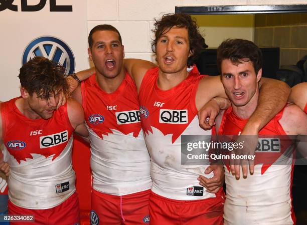 Dane Rampe, Lance Franklin, Kurt Tippett and Dean Towers of the Swans sing the song in the rooms after winning the round 22 AFL match between the...