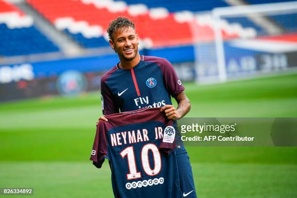 Brazilian superstar Neymar poses with his new jersey during his official presentation at the Parc des Princes stadium on August 4, 2017 in Paris...