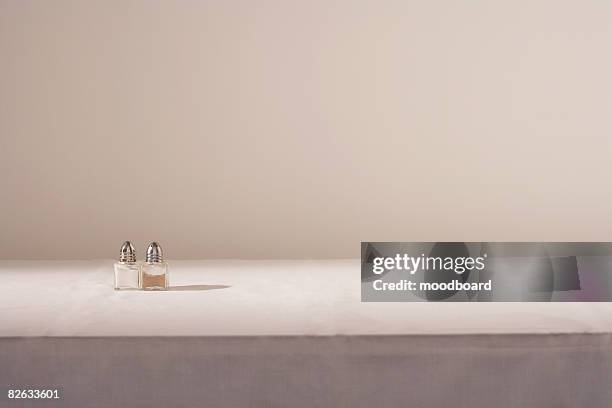 salt and pepper shakers on table - tischtuch stock-fotos und bilder