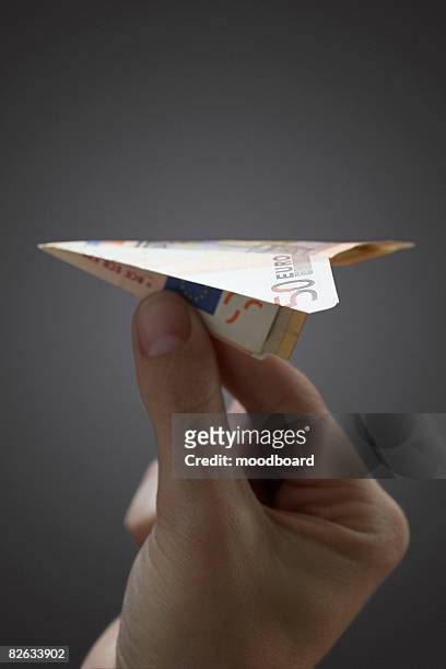 person holding paper airplane made of 50 euro note, close-up of hand - all european currencies stock pictures, royalty-free photos & images