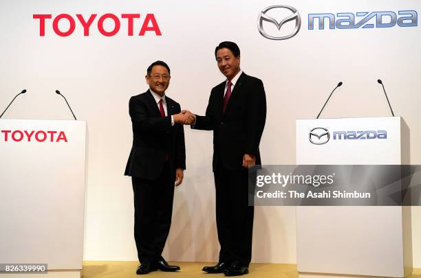 Toyota Motor Co. President Akio Toyoda and Mazda Motor Co. President and CEO Masamichi Kogai shake hands during a photo session at a joint press...