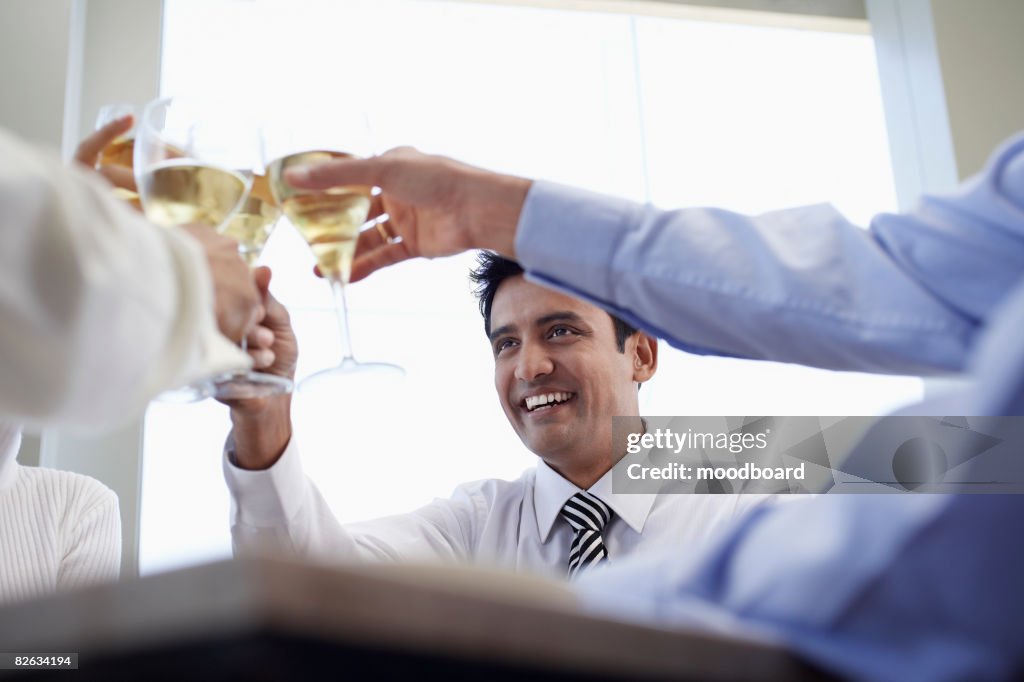 Business associates toasting with wine glasses, close-up