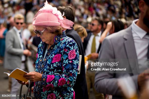 Racegoer checks her racecard on day four of the Qatar Goodwood Festival at Goodwood racecourse on August 4, 2017 in Chichester, England.