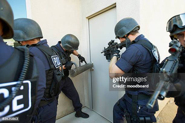 police officers breaking down doors - police confrontation stock pictures, royalty-free photos & images