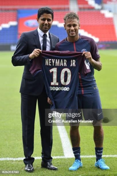Neymar poses with his new jersey next to Paris Saint-Germain President Nasser Al-Khelaifi after a press conference on August 4, 2017 in Paris,...