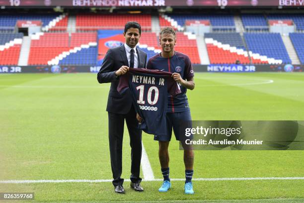 Neymar poses with his new jersey next to Paris Saint-Germain President Nasser Al-Khelaifi after a press conference on August 4, 2017 in Paris,...