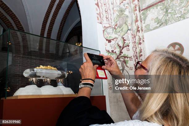 Tourist takes a photo of the model of the sarcophagus originally dedicated Queen Margrethe and Prince Hnerik in Ropskilde Cathedral on August 4, 2017...