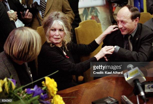Bridgitte Bardot reaches out to Traian Basescu, the mayor of Bucharest, Romania after signing an agreement with the city March 1, 2001 regarding the...