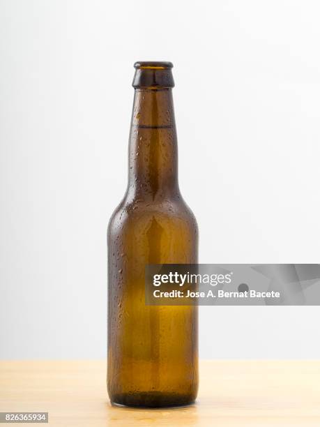 bottle of beer with the glass esmerilado with drops of water and a steam cloud frozen on a white bottom - botella de cerveza fotografías e imágenes de stock
