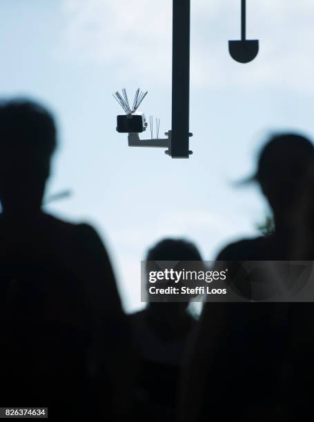 Passersby walk under a surveillance camera which is part of facial recognition technology test at Berlin Suedkreuz station on August 3, 2017 in...