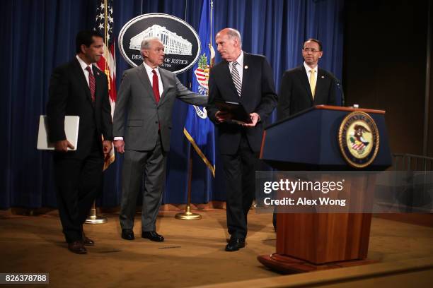 Attorney General Jeff Sessions and Director of National Intelligence Dan Coats share a moment as Deputy Attorney General Rod Rosenstein and National...