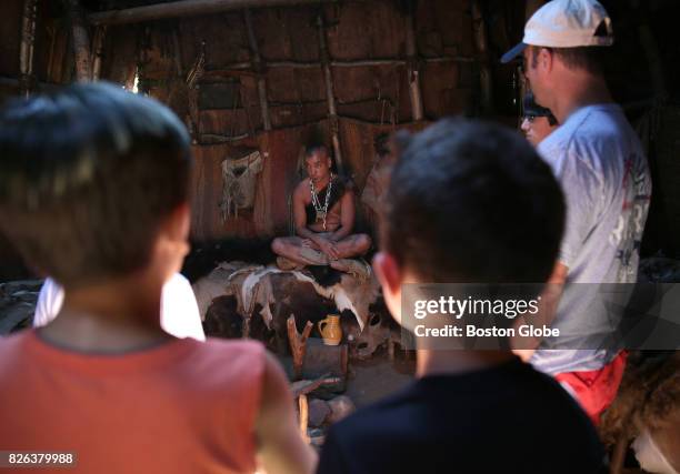 Visitors listen to Costumed Role Player Tim Turner at the Wampanoag Homesite at Plimoth Plantation in Plymouth, MA on Jul. 26, 2017.