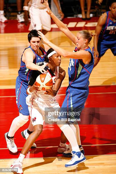 Michelle Snow of the Houston Comets is double teamed by Cathrine Kraayeveld and Janel McCarville of the New York Liberty at Reliant Arena on...