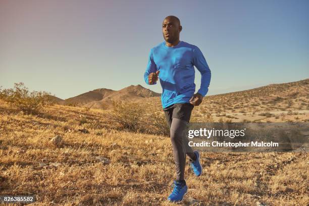 black man runs across hills - man running foto e immagini stock