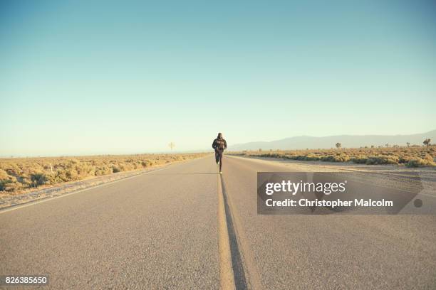 black man runs down open road - wide shot stock pictures, royalty-free photos & images