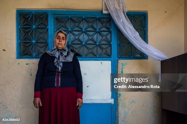 June 2015 - Ergani, Turkey. Hanim Kaya mother of Mutlu Kaya poses for a portrait outside the house where Mutlu was shot in the head on the night of...