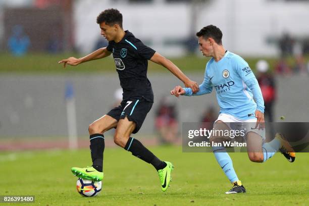 Nathan Holland of West Ham United and Phil Foden of Manchester City battle for possession during a Pre Season Friendly between Manchester City and...