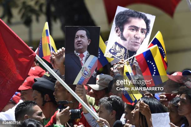 Government supporters carry images of late Venezuelan President Hugo Chavez and Venezuelan Liberator Simon Bolivar during a rally in Caracas on the...