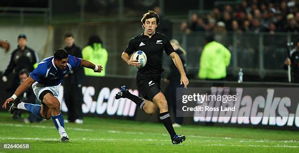 Conrad Smith of the All Blacks runs away from Alafoti Faosiliva of Samoa in action during the rugby test match between New Zealand and Samoa at...