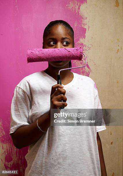 woman holding paint roller across face - self doubt ストックフォトと画像