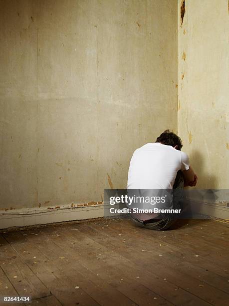 man sitting in corner - fragility stock pictures, royalty-free photos & images