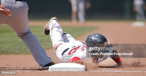 Joseph Monge beats the tag by Flying Squirrels first baseman K.C. Hobson while diving back to first base during a game against Richmond on Thursday,...