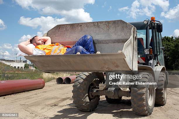 man asleep in bucket of earth mover - pauze nemen stockfoto's en -beelden