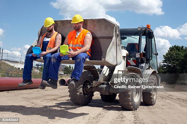 2 construction workers eating lunch on digger - daily bucket stockfoto's en -beelden