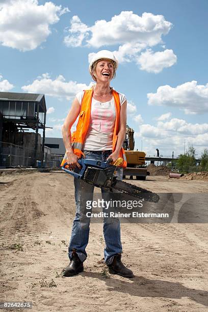 female construction worker holding chainsaw - female builder stock pictures, royalty-free photos & images