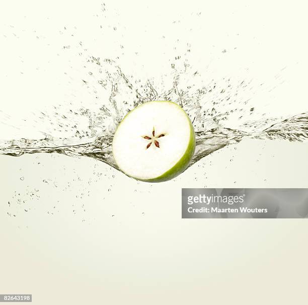 apple splashing in water - apple water splashing stock pictures, royalty-free photos & images