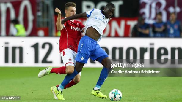 Wilson Kamavuaka of Darmstadt challenges Gino Fechner of Kaiserslautern during the Second Bundesliga match between 1. FC Kaiserslautern and SV...