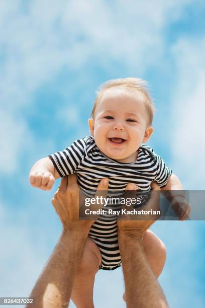 baby being held high - baby being held stockfoto's en -beelden